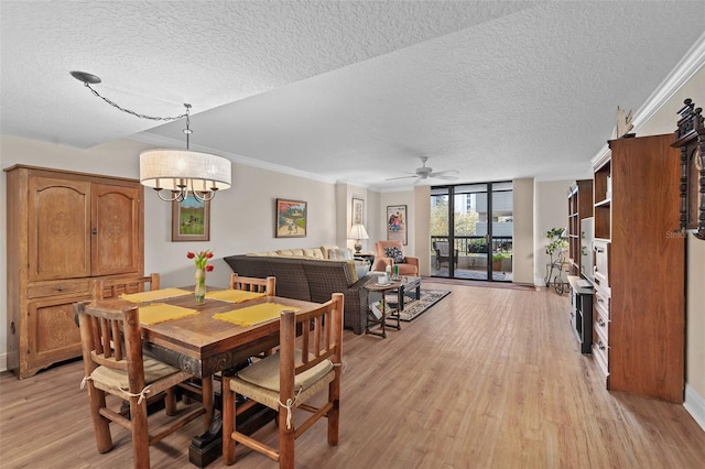 dining space featuring a textured ceiling, ornamental molding, expansive windows, and light wood-type flooring