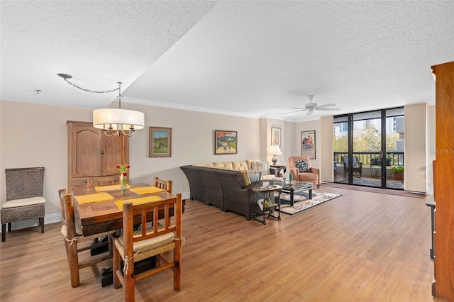 dining area with a textured ceiling, floor to ceiling windows, baseboards, and light wood-style floors