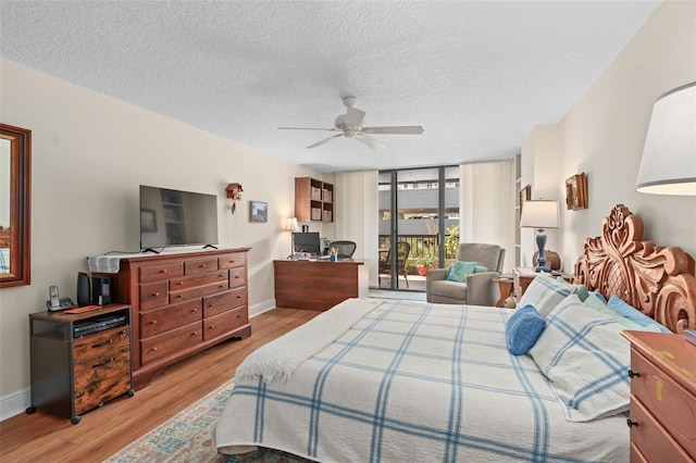 bedroom featuring expansive windows, access to outside, baseboards, and light wood finished floors