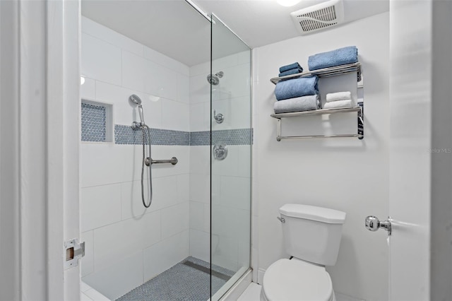 full bathroom featuring toilet, a shower stall, and visible vents