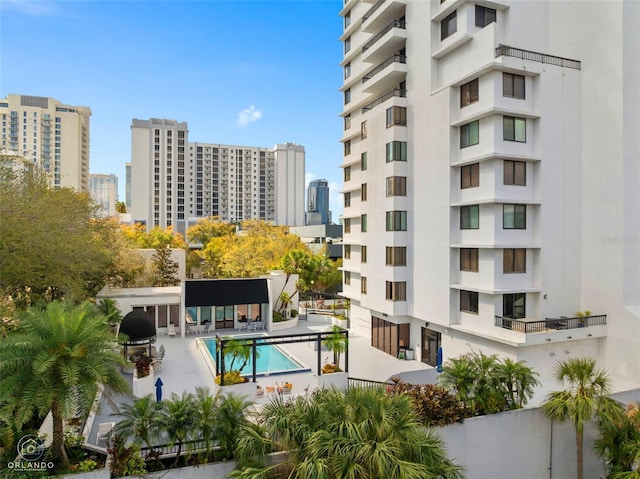 view of building exterior with a city view and a community pool