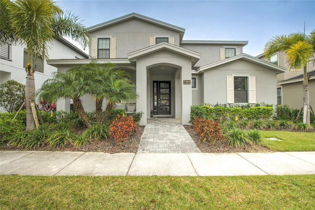 view of front facade with a front lawn and stucco siding