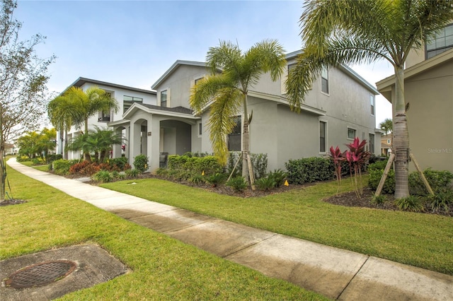 view of side of property with a lawn and stucco siding