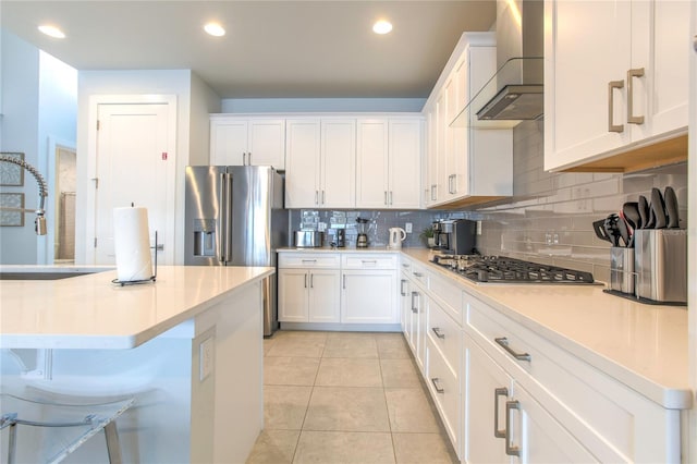 kitchen featuring light tile patterned floors, light countertops, white cabinetry, a sink, and wall chimney exhaust hood