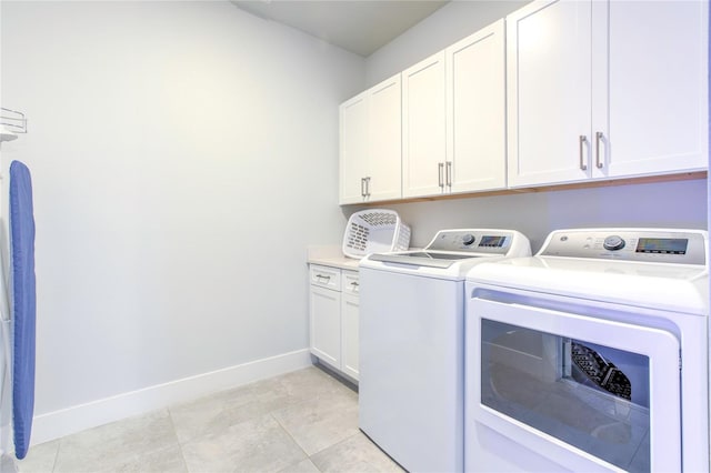 laundry area featuring cabinet space, light tile patterned flooring, baseboards, and independent washer and dryer