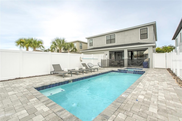 view of pool with a pool with connected hot tub, a fenced backyard, and a patio