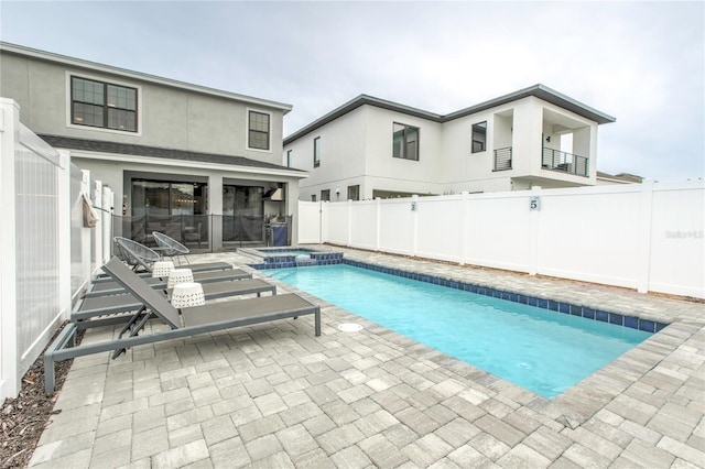 view of swimming pool with a patio area, a fenced backyard, and a pool with connected hot tub