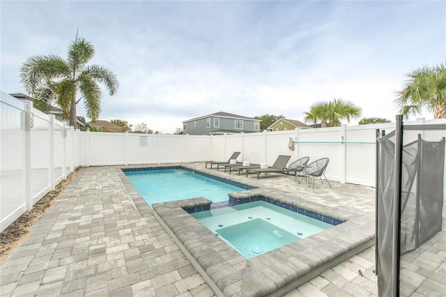 view of swimming pool with a patio, a fenced backyard, and a pool with connected hot tub