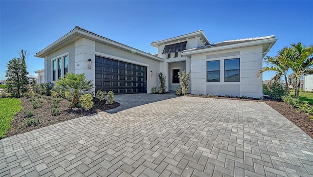 view of front of property with a garage, decorative driveway, and stucco siding