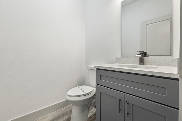 bathroom featuring wood finished floors, vanity, and toilet