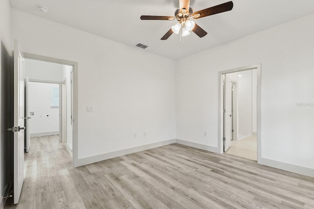 spare room with a ceiling fan, visible vents, light wood-style flooring, and baseboards