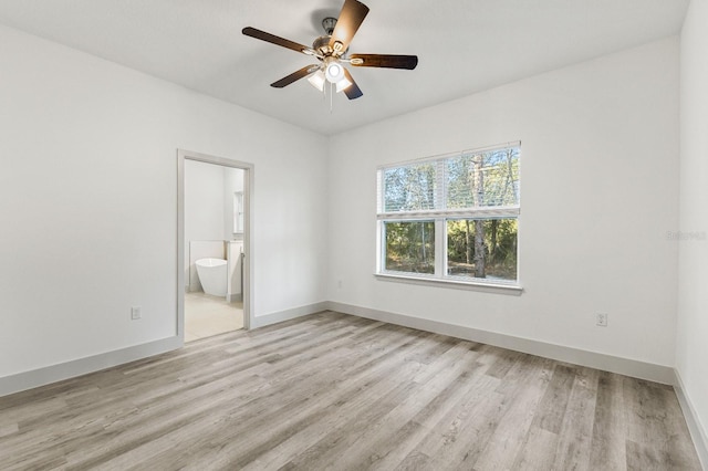 unfurnished bedroom featuring light wood-style floors, ceiling fan, baseboards, and ensuite bathroom