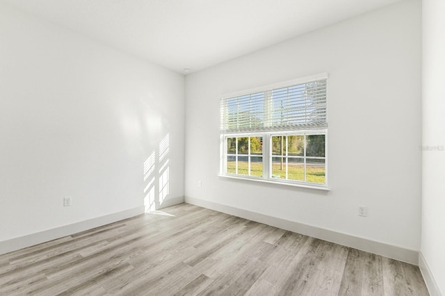 empty room featuring baseboards and wood finished floors