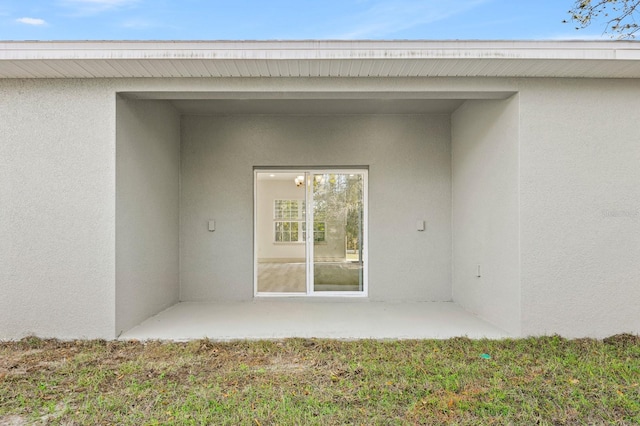 entrance to property featuring stucco siding