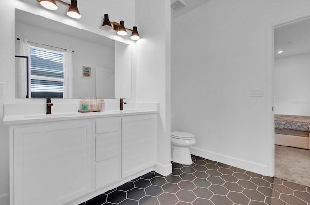 bathroom with double vanity, visible vents, toilet, and a sink
