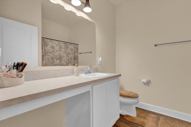 full bathroom with wood finished floors, toilet, vanity, baseboards, and curtained shower