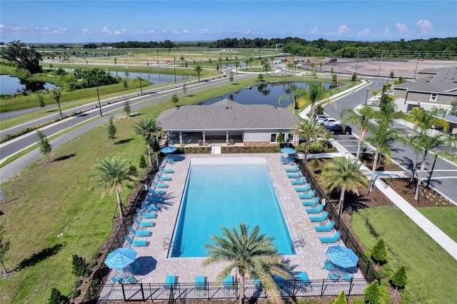 view of swimming pool featuring a water view and fence