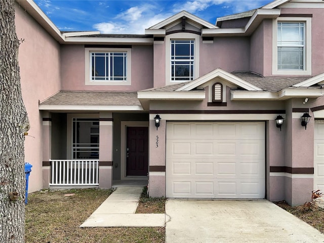 multi unit property with driveway, a shingled roof, and stucco siding