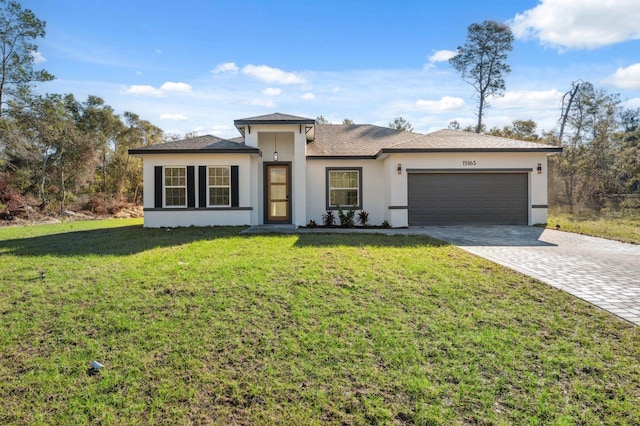 view of front of property with an attached garage, stucco siding, decorative driveway, and a front yard