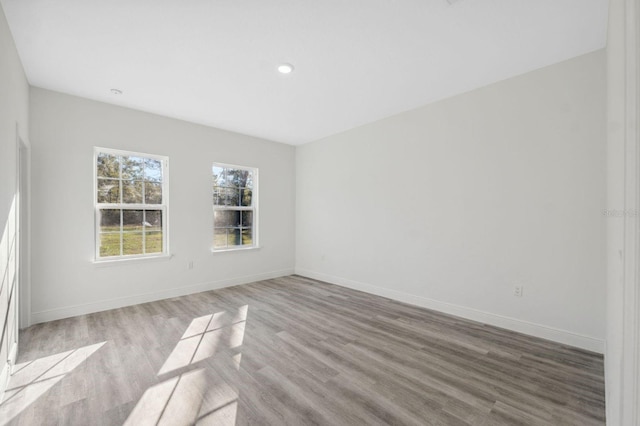 unfurnished room with baseboards and wood finished floors