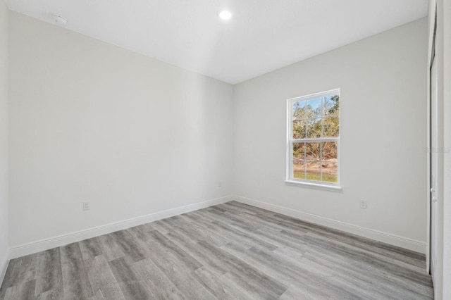 spare room featuring baseboards and wood finished floors