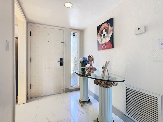 entryway with visible vents, marble finish floor, and decorative columns