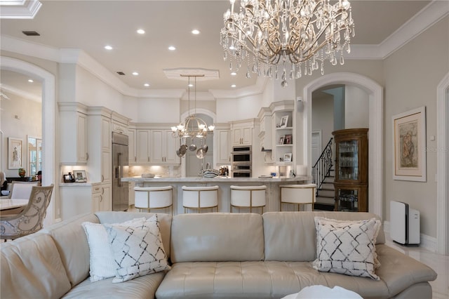 living area with visible vents, arched walkways, a high ceiling, crown molding, and a chandelier