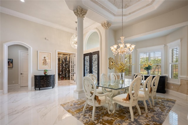 dining room with marble finish floor, a chandelier, and ornate columns