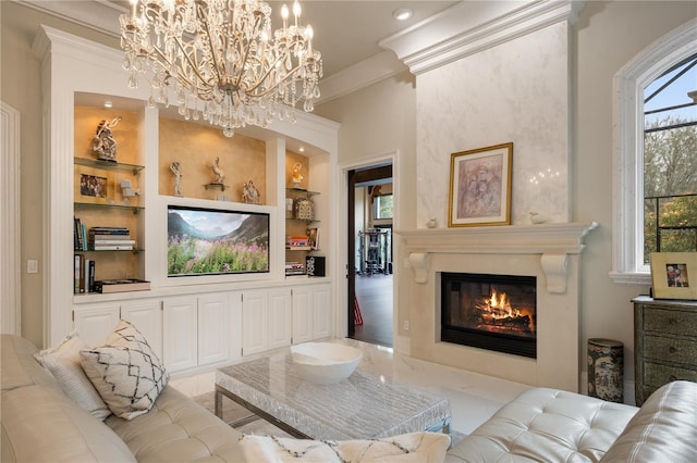 living room with a glass covered fireplace, crown molding, built in shelves, and an inviting chandelier