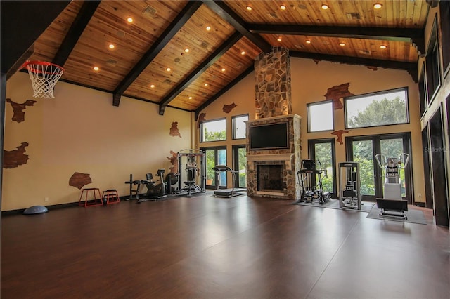 workout area featuring a stone fireplace, wooden ceiling, plenty of natural light, and high vaulted ceiling