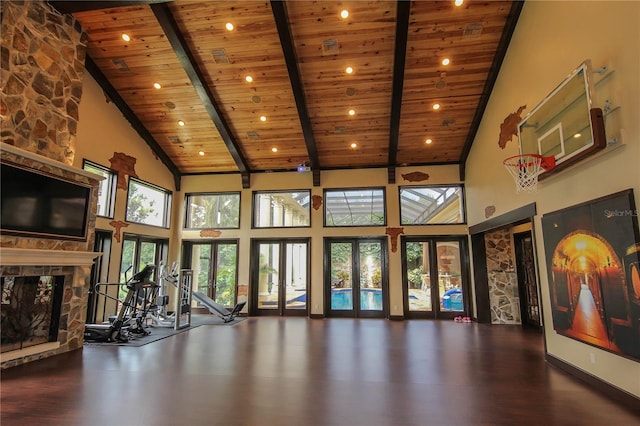 workout area with high vaulted ceiling, wood finished floors, french doors, a stone fireplace, and wood ceiling