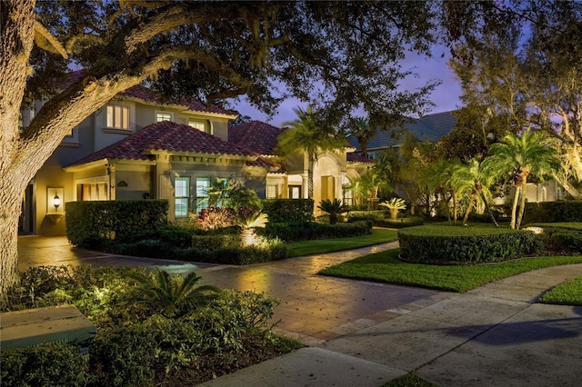 mediterranean / spanish-style home with a tiled roof and stucco siding