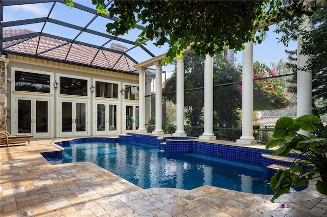 view of pool with glass enclosure, a patio, french doors, and a pool with connected hot tub