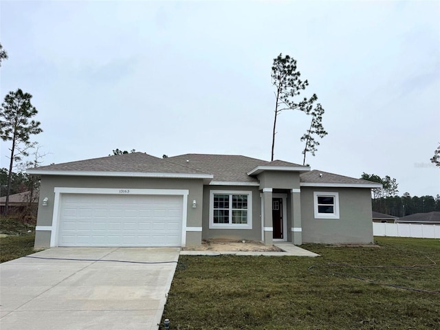 view of front of property with concrete driveway, a front lawn, an attached garage, and stucco siding