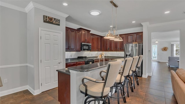 kitchen featuring a breakfast bar area, decorative light fixtures, black electric range, dark countertops, and a center island with sink