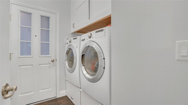 laundry room featuring cabinet space, dark tile patterned floors, and independent washer and dryer