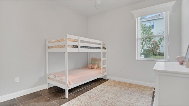 bedroom featuring dark tile patterned floors and baseboards