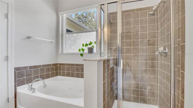 bathroom with a shower stall and a bath