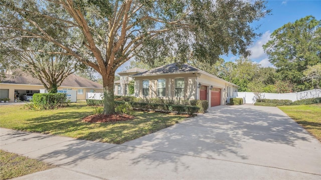 bungalow featuring an attached garage, driveway, a front yard, and fence