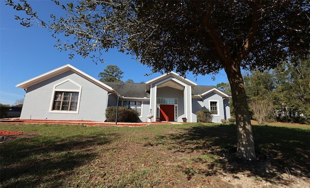 ranch-style home with a front yard and stucco siding