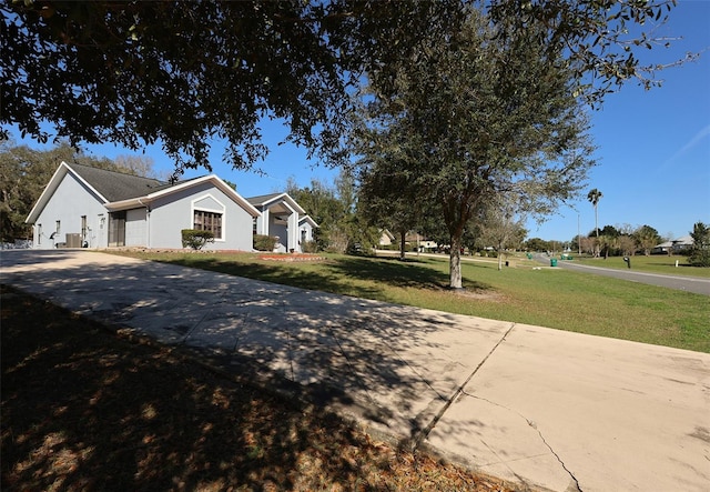 view of front facade with a front yard and stucco siding