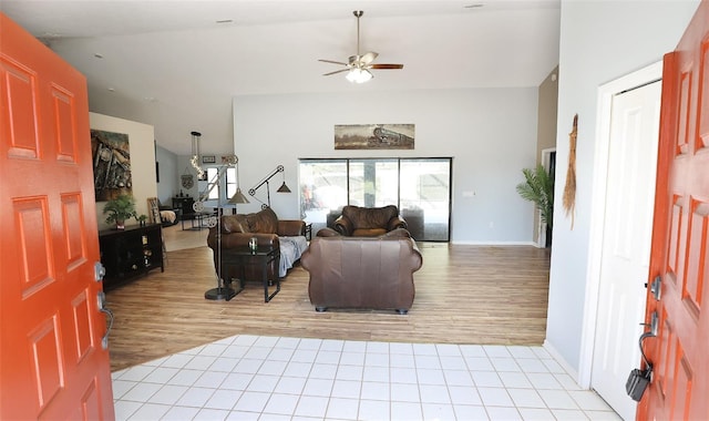 living room featuring light tile patterned floors, ceiling fan, and baseboards