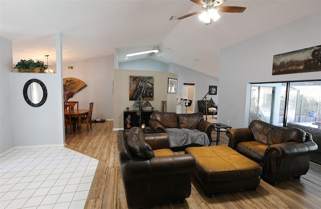 living area featuring light wood-style floors, lofted ceiling, ceiling fan, and baseboards