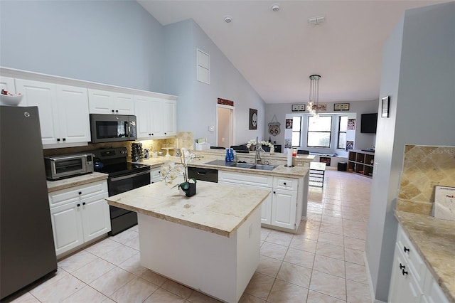 kitchen with a sink, white cabinets, a center island, black appliances, and pendant lighting