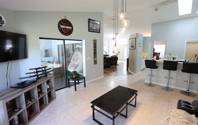 living room with high vaulted ceiling, baseboards, and light tile patterned floors