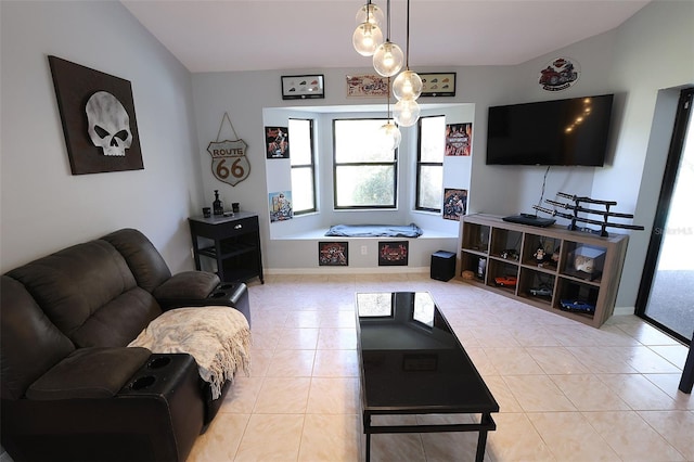 living area with vaulted ceiling, baseboards, and light tile patterned floors