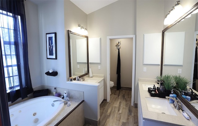 full bathroom featuring wood finished floors, plenty of natural light, vanity, and toilet