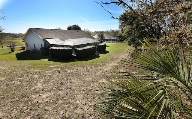 view of property exterior featuring fence, a lawn, and stucco siding