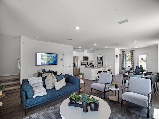 living area featuring baseboards, visible vents, stairway, dark wood-type flooring, and recessed lighting