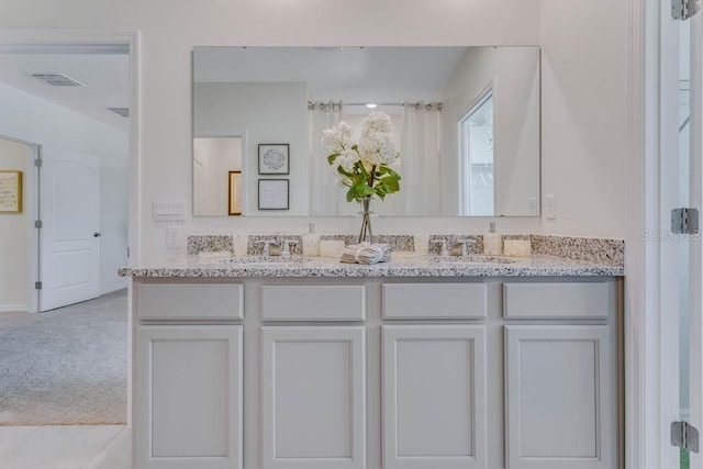 full bath featuring double vanity, a sink, and visible vents